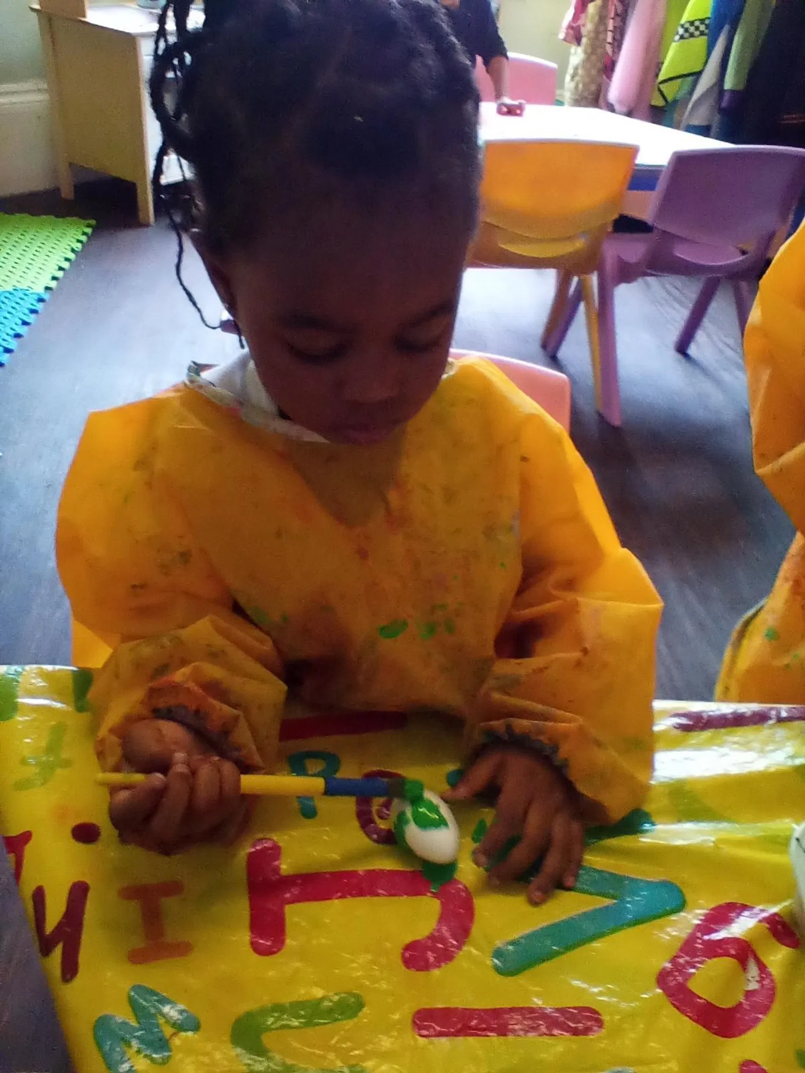 A preschool child concentrating on a painting activity